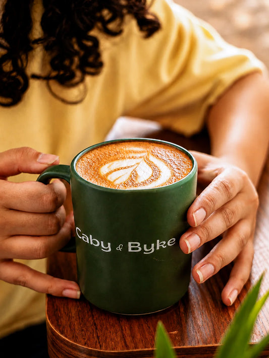 Freshly brewed hot mocha coffee with latte art served in a Caby & Byke mug at a cozy café.